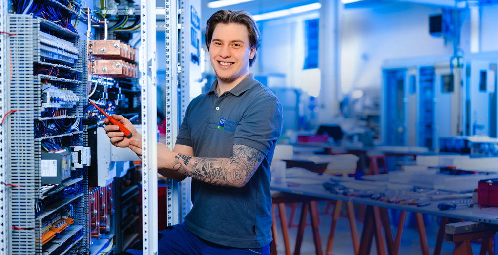 HPS Home - Worker is standing at the control panel and adjusting the controller